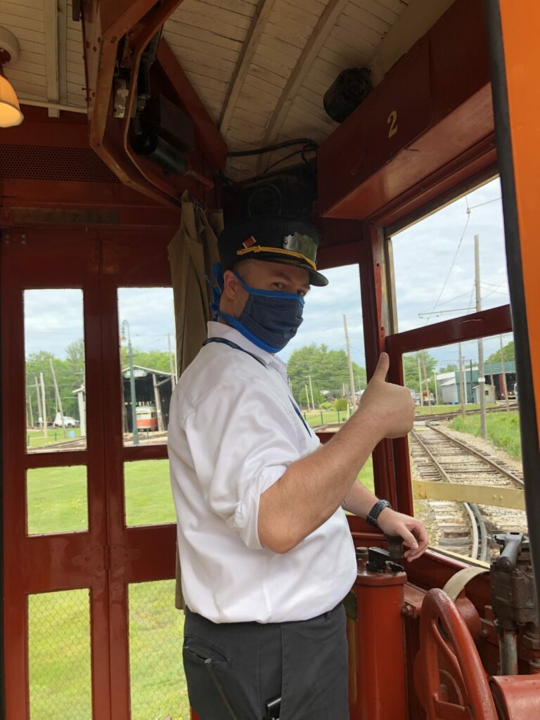 trolley conductor giving thumbs up while operating trolley
